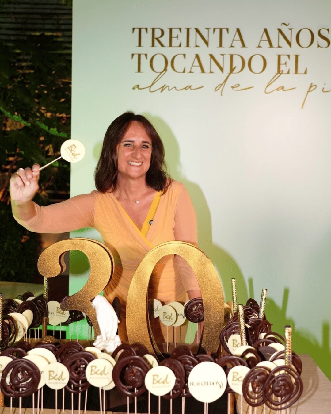 Silvia Oliete con un pastel de piruletas con dibujos de felices 30 años