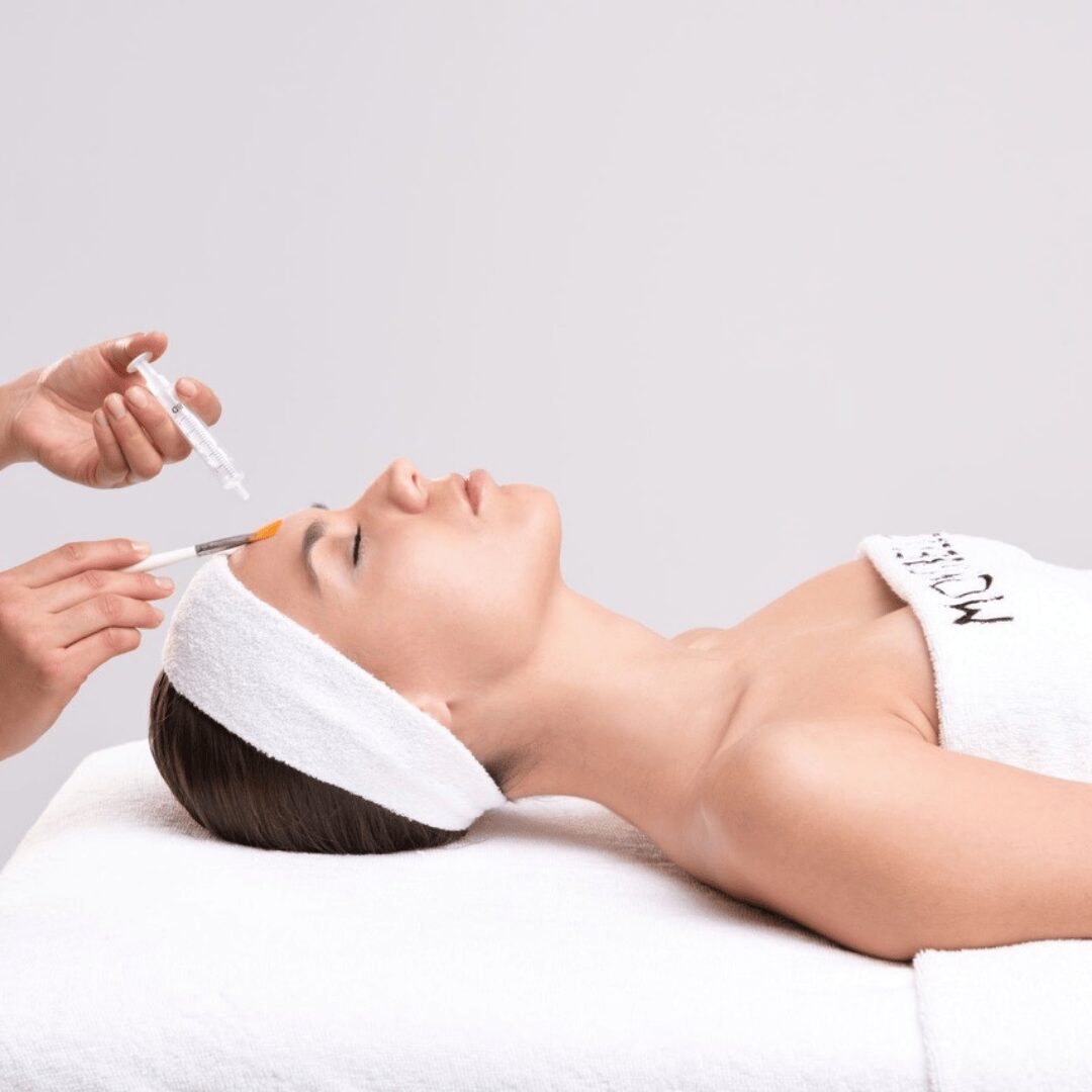 Chica estirada en una camilla donde se le suministra el producto Montibello.