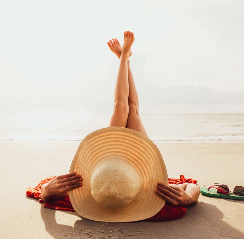 Chica en la playa con una pamela