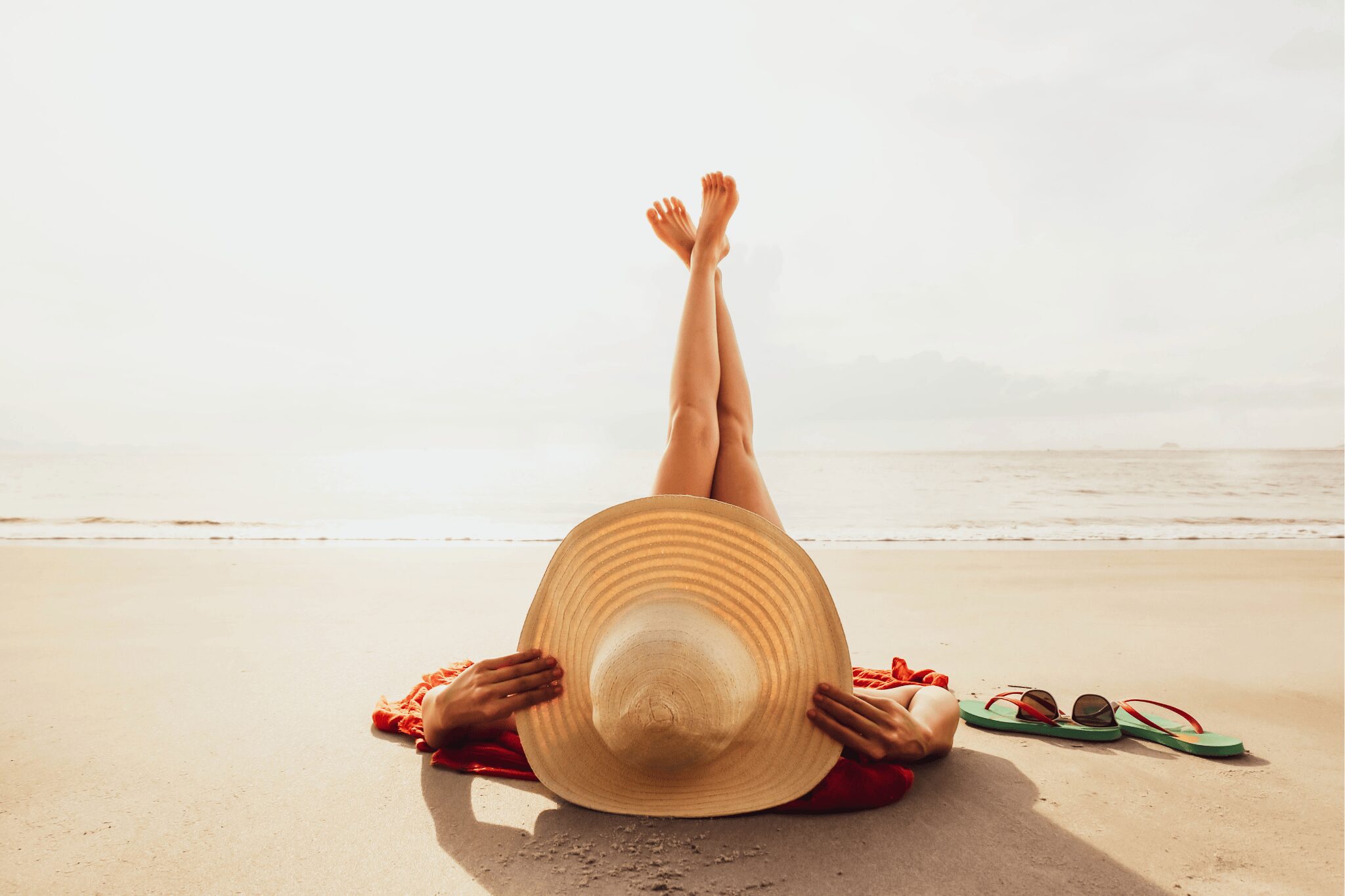 Chica en la playa con una pamela