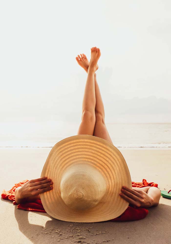 Chica en la playa con una pamela