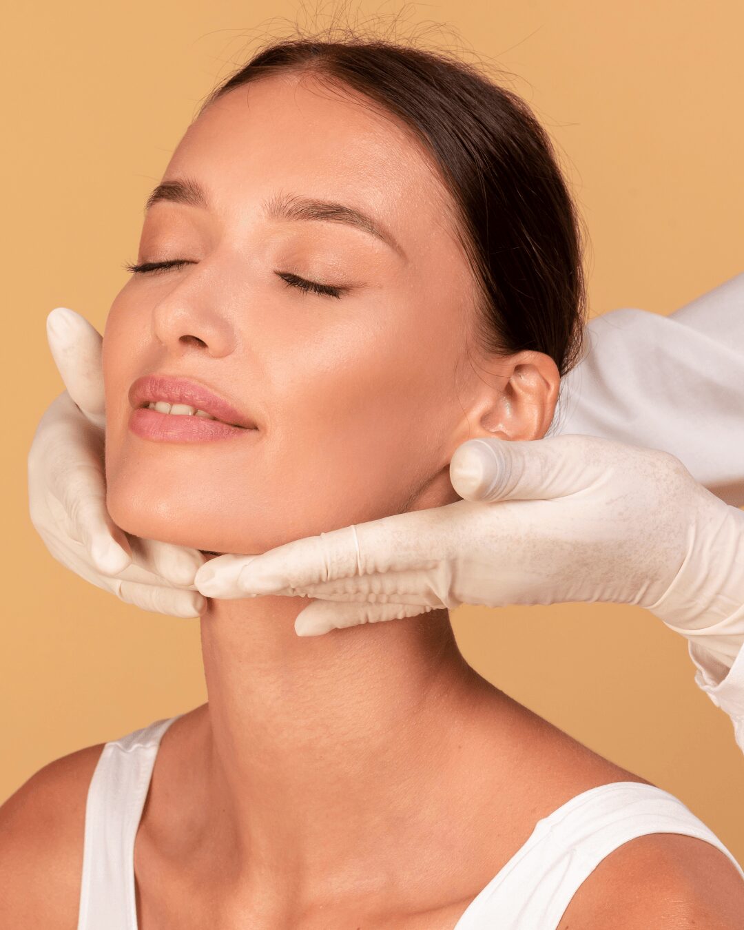 Unas manos con guantes sujetando la cara de una chica joven