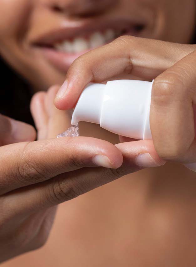 Una chica aplicándose una crema con retinol y péptidos
