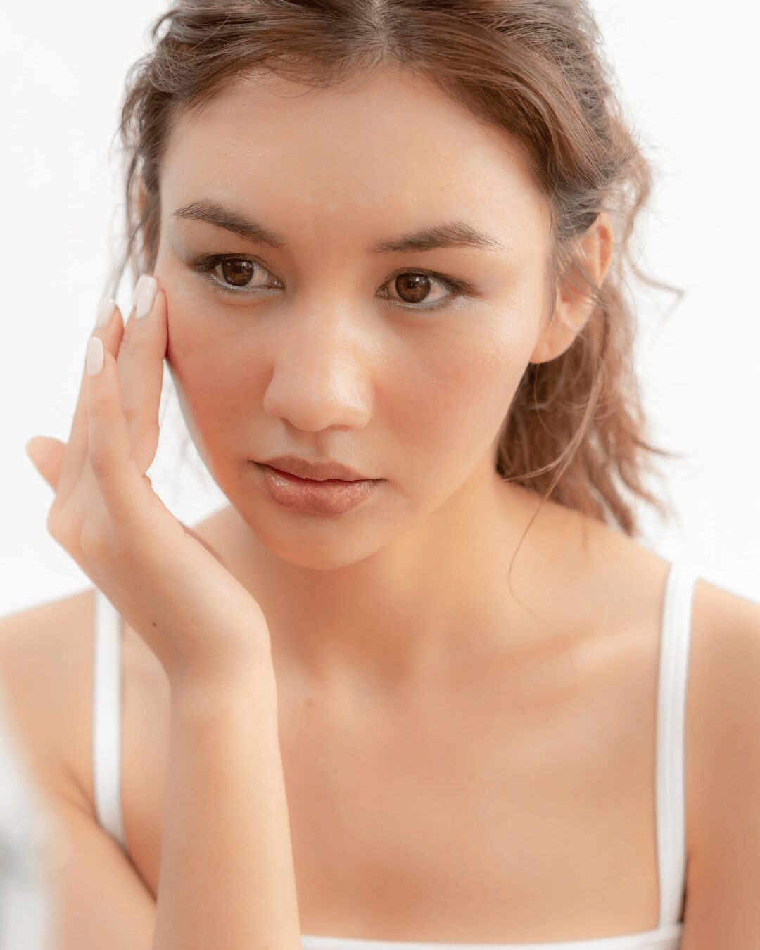 Chica joven aplicándose crema facial