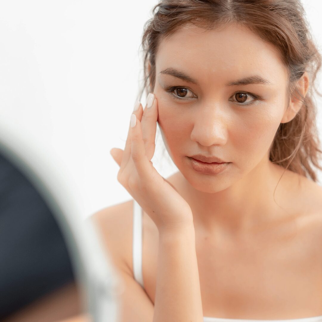 Chica joven aplicándose crema facial