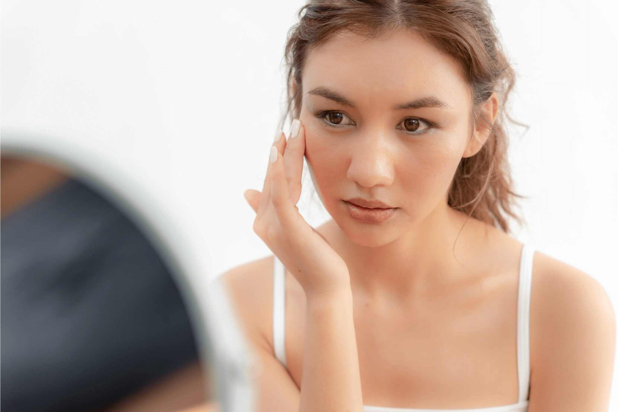 Chica joven aplicándose crema facial